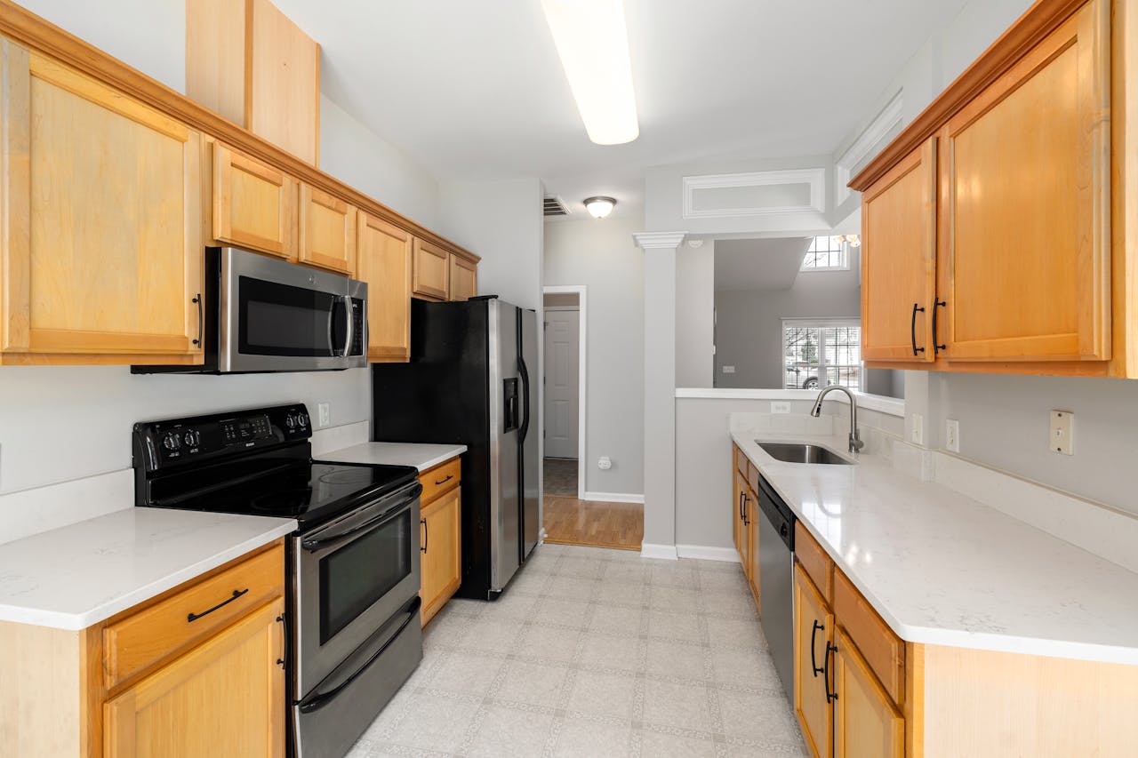 Spacious kitchen featuring wooden cabinets, modern appliances, and a bright ambiance.