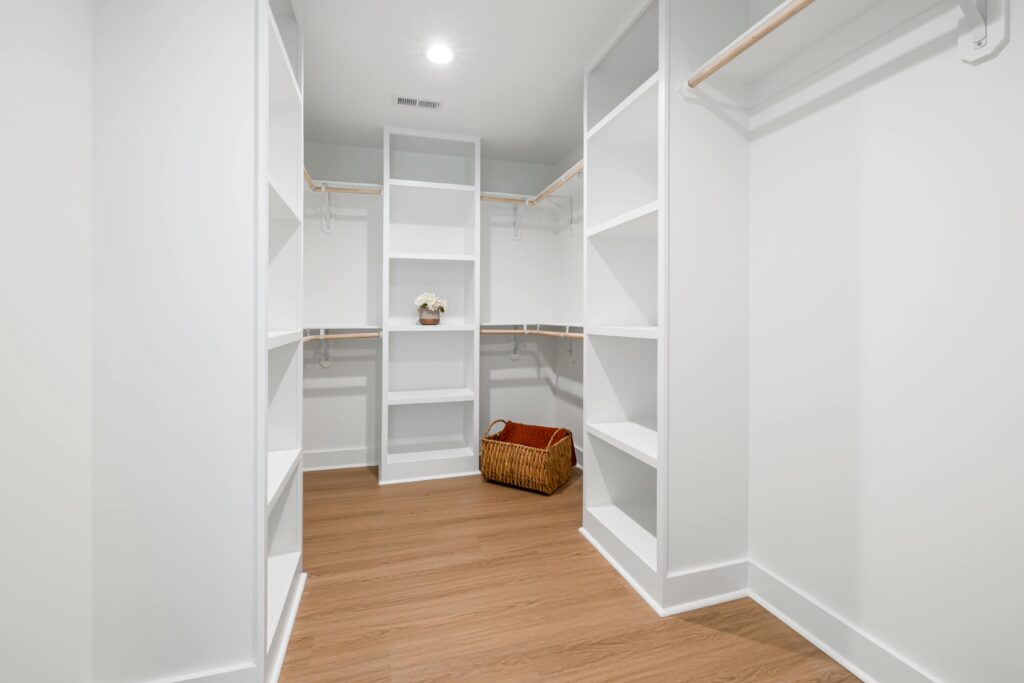 pexels-photo-8031884-8031884 Spacious white walk-in closet with wooden flooring and organized shelves for an elegant and minimalist look.